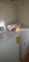 Laundry Room has a washer, dryer, laundry detergent, fabric sheets, iron and ironing board.